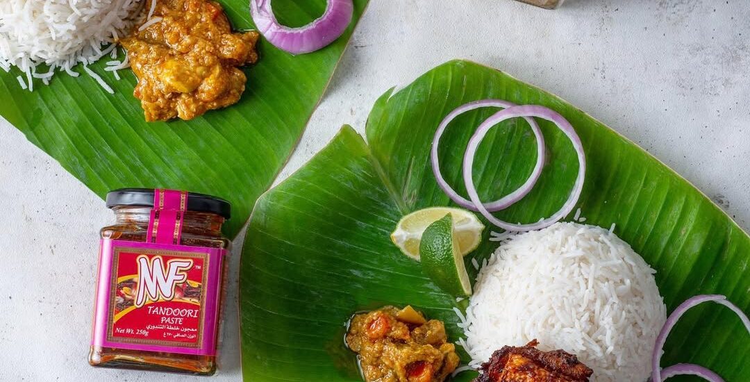 A visual of two food-filled plates alongside a jar of sauce, presenting a tempting culinary arrangement.